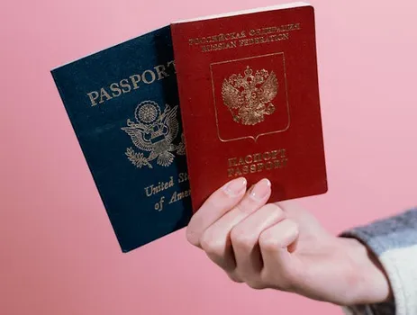 A hand holding up a pair of passports.