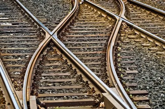 A close-up image of parallel train tracks connected by a switch.