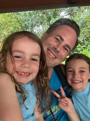 Ryan smiling with two girls.